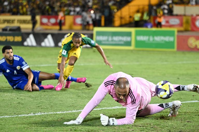 Curacao's goalkepper #01 Eloy Room (R) makes a save in a scoring attempt by Jamaica's forward #10 Bobby Reid (C) during the World Cup qualifier football match between Jamaica and Curacao at the National Stadium in Kingston, Jamaica on November 18, 2025. (Photo by Ricardo Makyn / AFP) (Photo by RICARDO MAKYN/AFP via Getty Images)          
